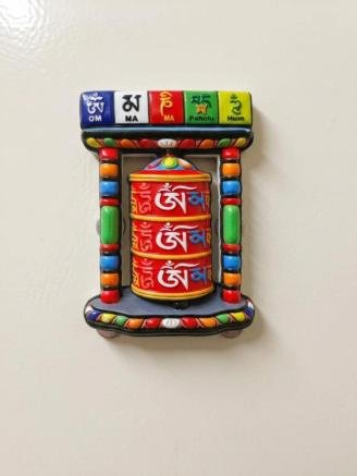 Handmade Tibetan prayer wheel fridge magnet featuring the Om Mani Padme Hum mantra